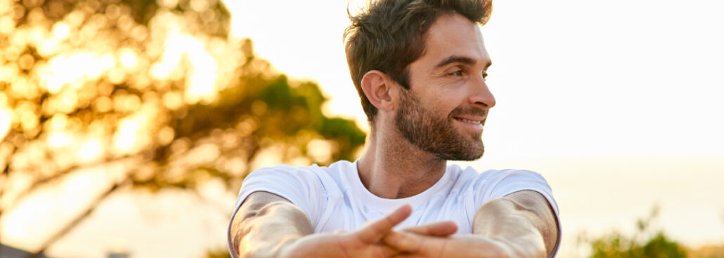 san diego naturopathic doctors smiling man stretching hands in sunset park