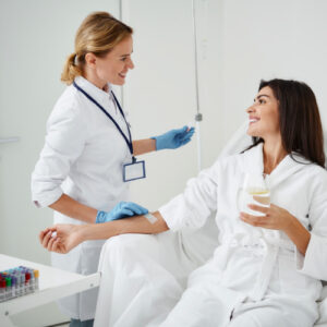 san diego naturopathic doctors smiling woman sitting receiving iv therapy treatment