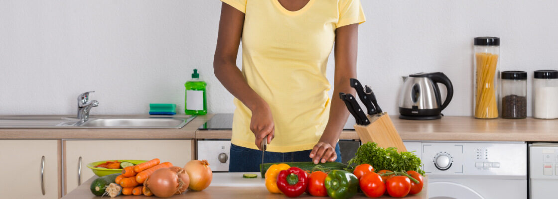 san diego naturopathic doctors woman cutting vegetables in kitchen