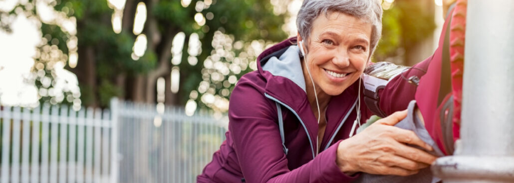 san diego naturopathic doctors woman smiling stretching leg on street pole