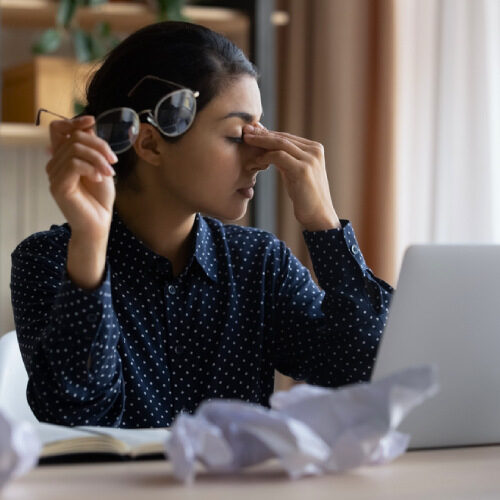 san diego naturopathic doctors exhausted woman rubbing eyes in front laptop