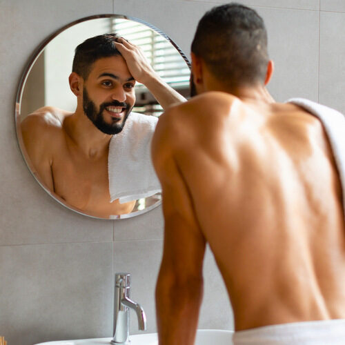 san diego naturopathic doctors man in towerl smiling into bathroom mirror