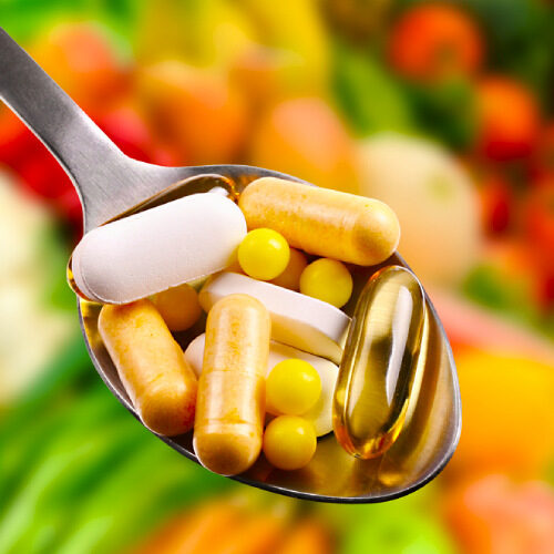 san diego naturopathic doctors spoon full of vitamin supplements in front of vegetables fruit