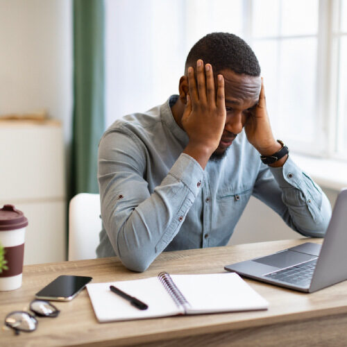 san diego naturopathic doctors tired stressed man holding head at work