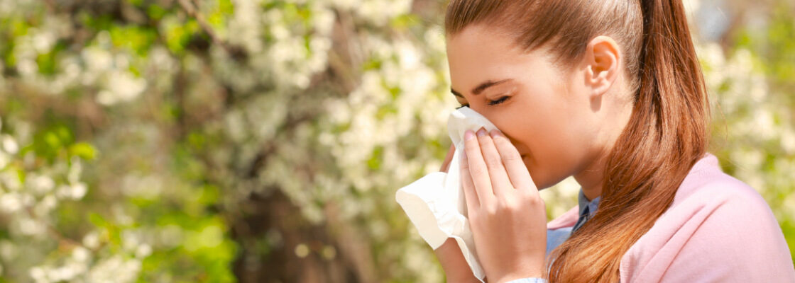 san diego naturopathic doctors woman sneezing due to allergies in park