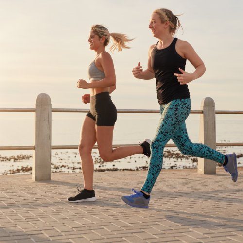 san diego naturopathic doctors two woman jogging along beachside walkway