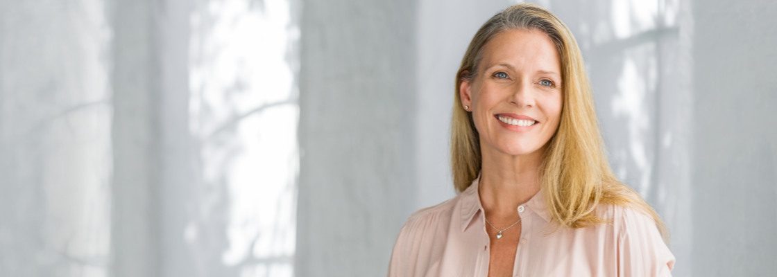 san diego naturopathic doctors woman smiling in front of gray background